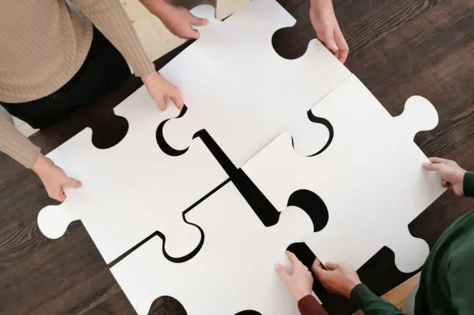 Collaborative Problem-Solving A close-up of puzzle pieces coming together, symbolizing collaborative problem-solving. This image is ideal for illustrating teamwork and strategic thinking, reflecting the process of aligning all parts of a business to achieve success.